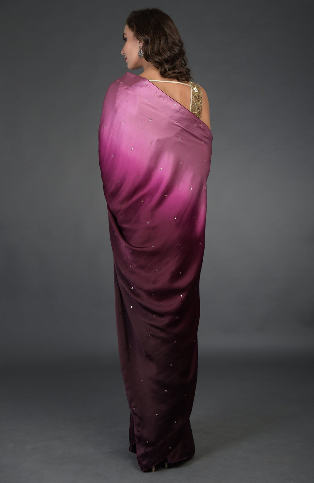 A woman models a wine-pink ombre sequin and zardozi hand-embroidered saree.