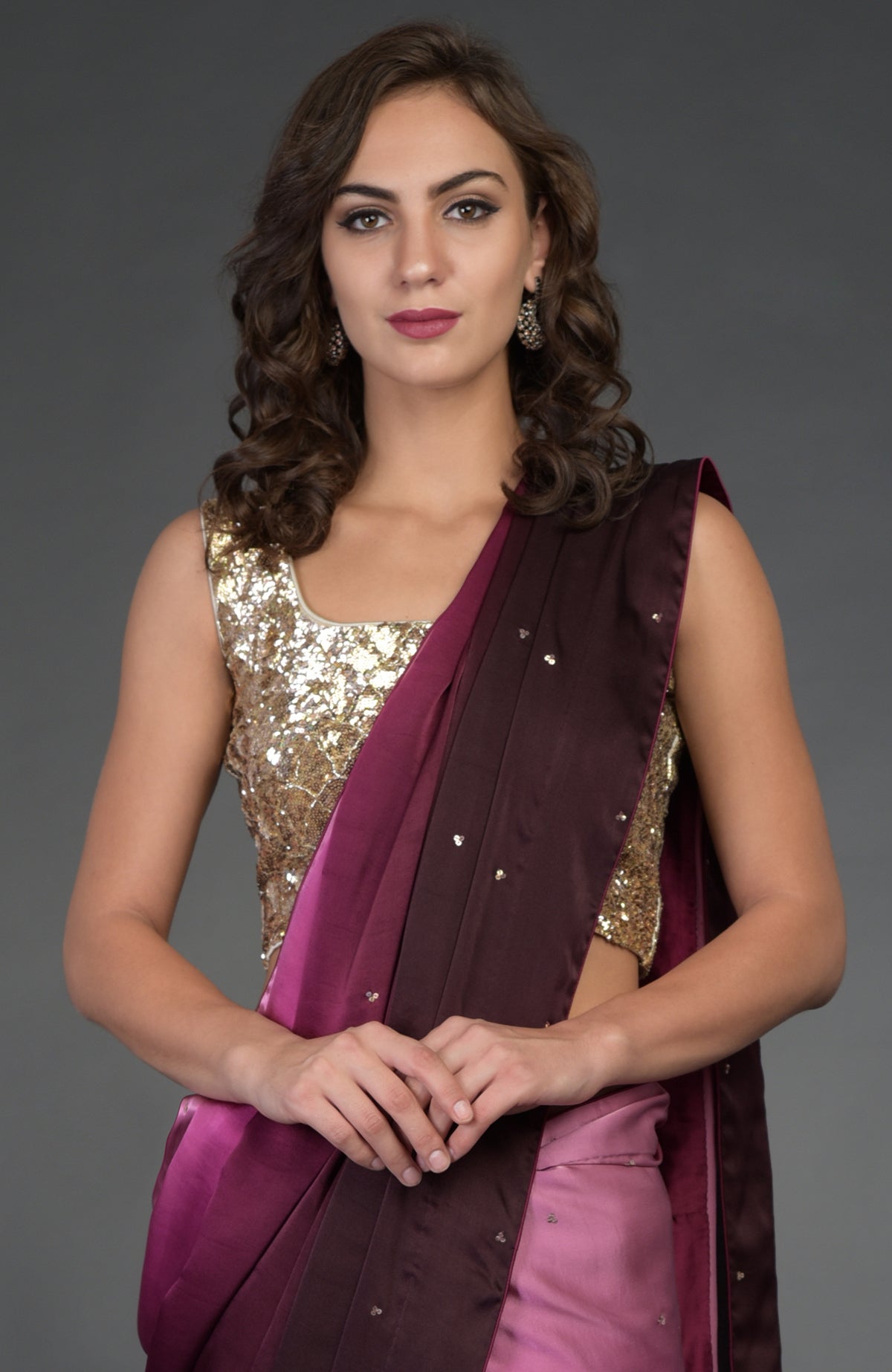 A woman models a wine-pink ombre saree with a gold sequin blouse.