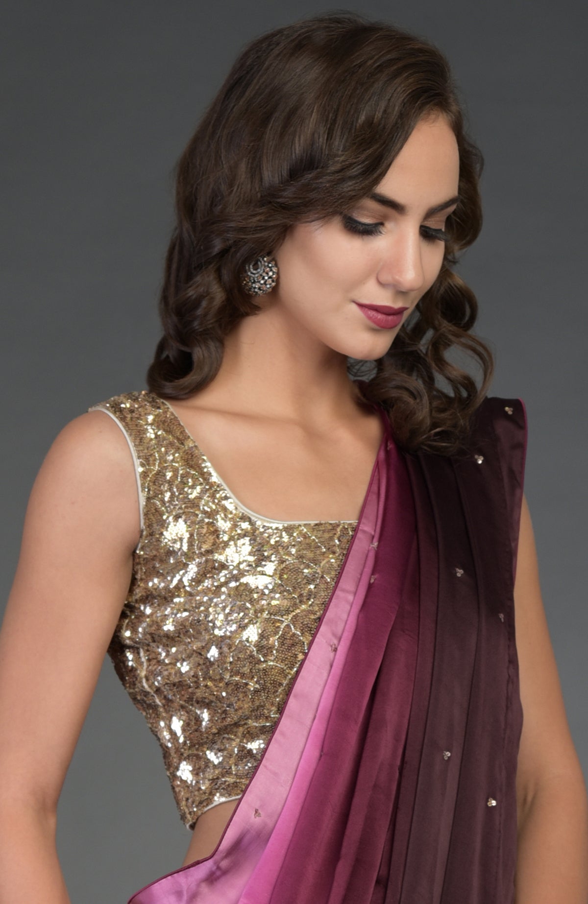 A woman models a wine-pink ombre sequin and zardozi hand-embroidered saree.
