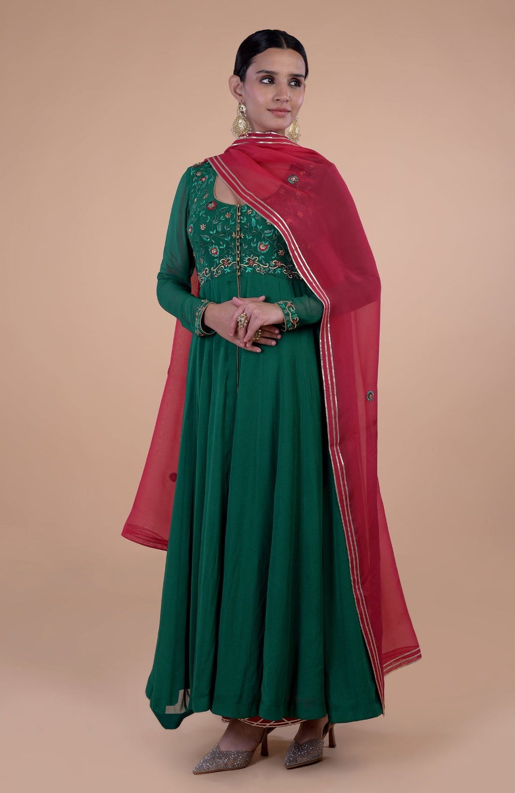 Emerald green anarkali set with red resham and zardozi embroidery.