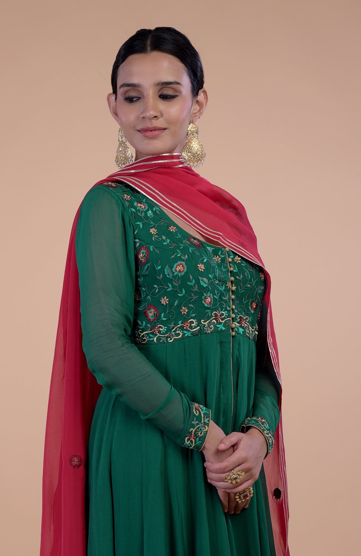 Anarkali set with emerald green kurta, red dupatta, and floral embroidery.