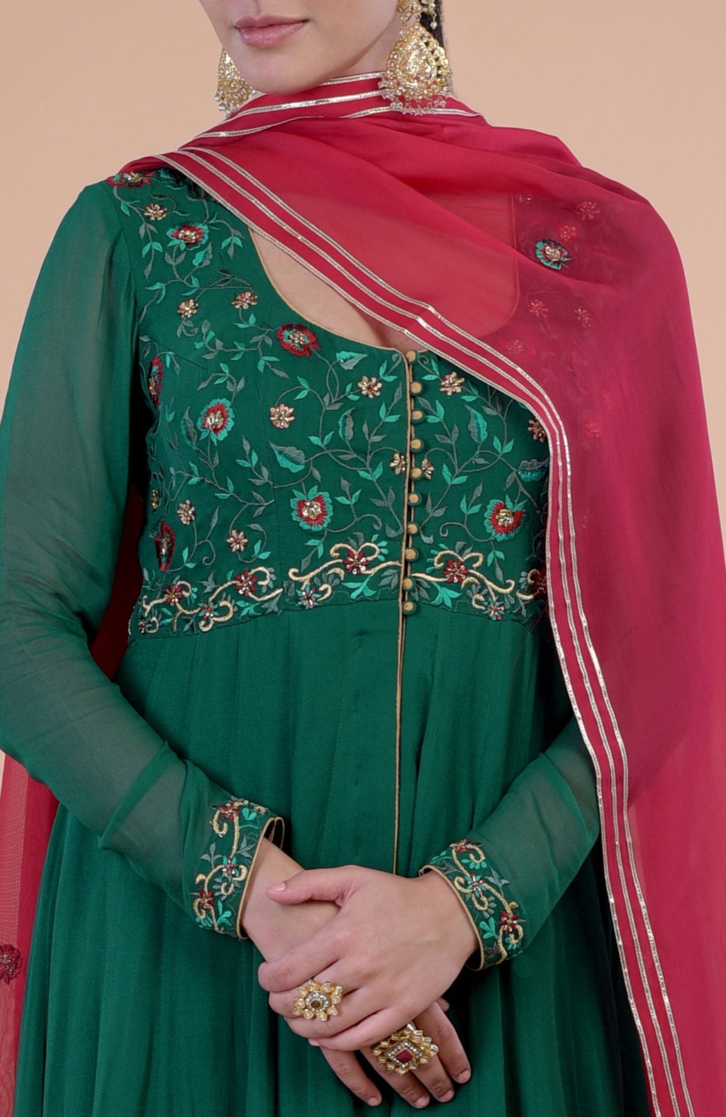 Emerald green Anarkali set with red resham and zardozi embroidery.