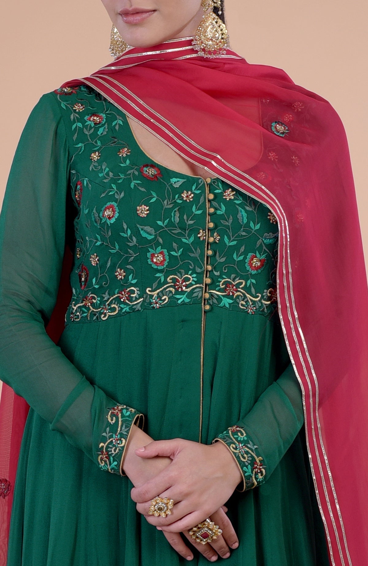 Emerald green Anarkali set with red resham and zardozi embroidery.