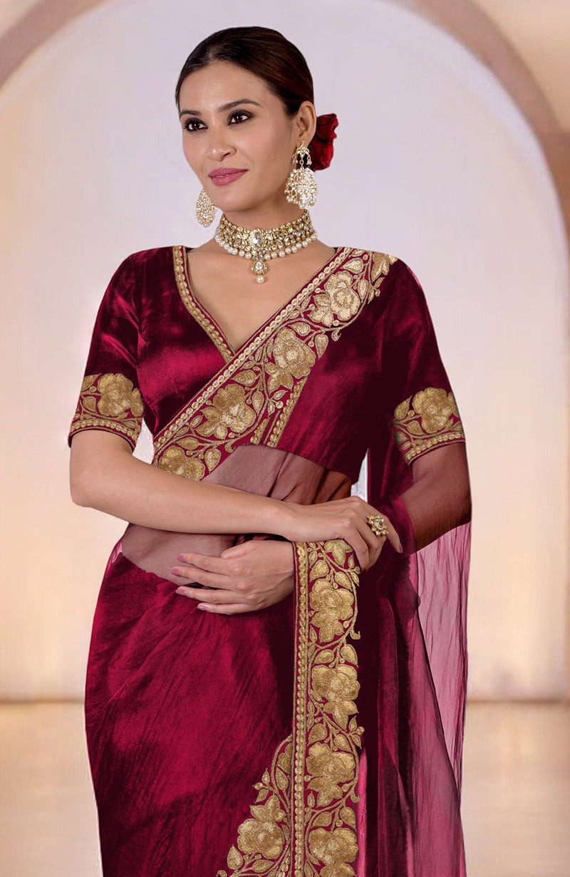 A woman models a blood red Kashmiri Tilla embroidered saree with a matching blouse.