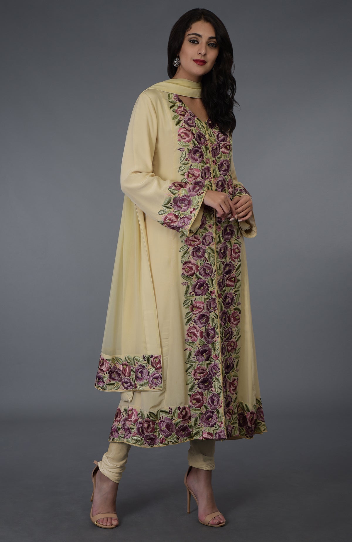 A woman models a lemon chiffon Parsi Gara embroidered suit with floral patterns.