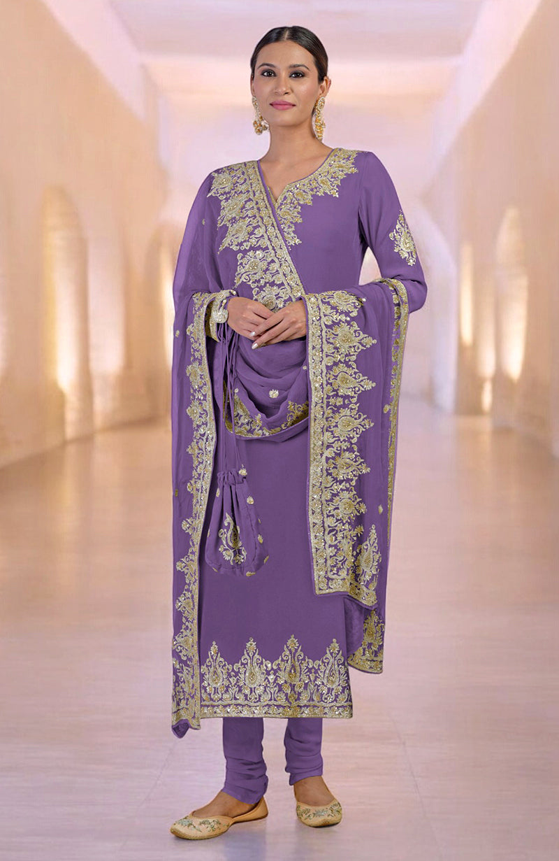 A woman models a purple kurta set with gold embroidery and a matching potli bag.