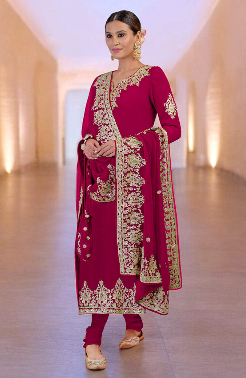 A woman models a bright rose gold Kashmiri kurta set with intricate embroidery.