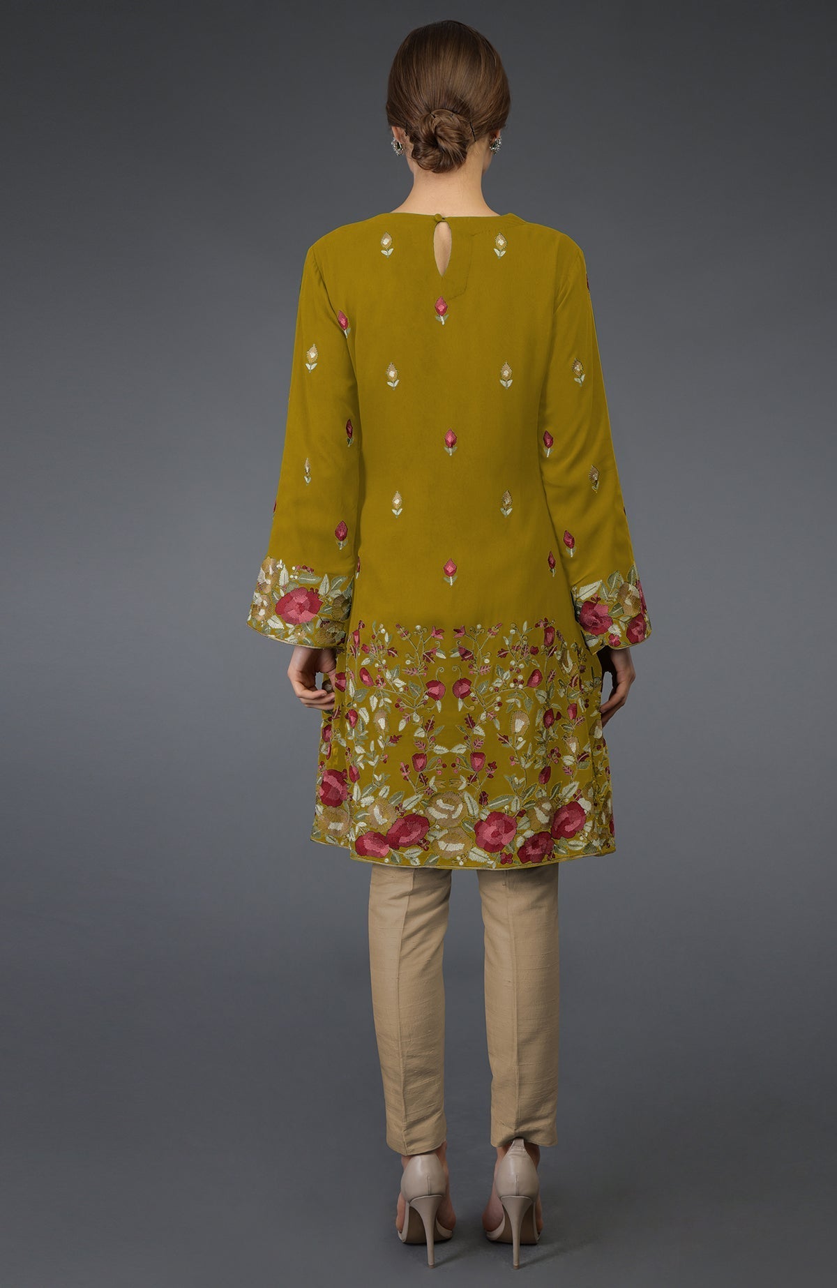 Mustard Parsi embroidered tunic suit with beige pants and nude heels.