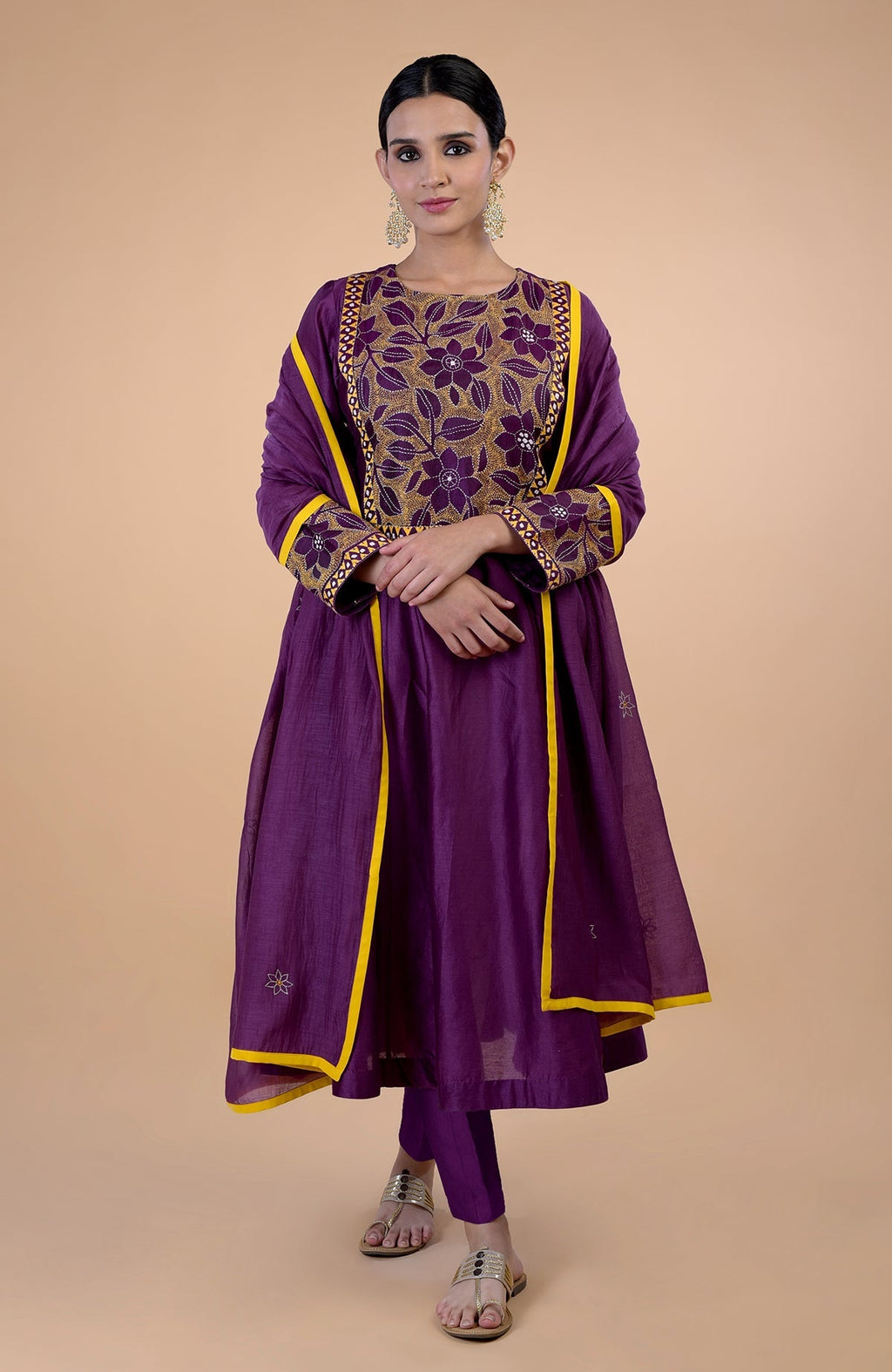 A woman models a plum Kantha hand-embroidered kalidaar kurta set with mustard accents.
