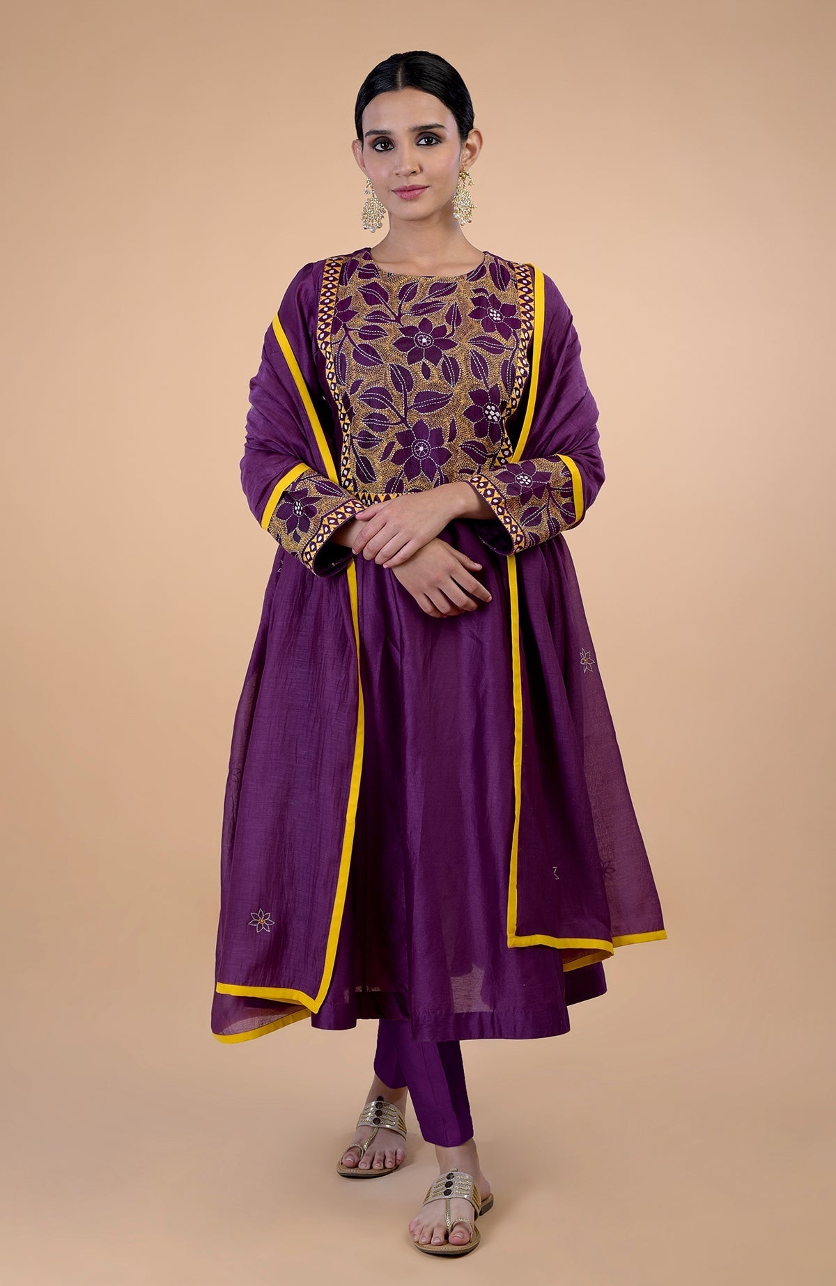 A woman models a plum Kantha hand-embroidered kalidaar kurta set with mustard accents.