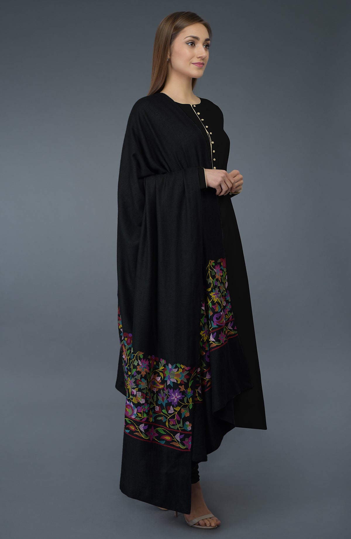 A woman models a black suit with a colorful, embroidered dupatta.