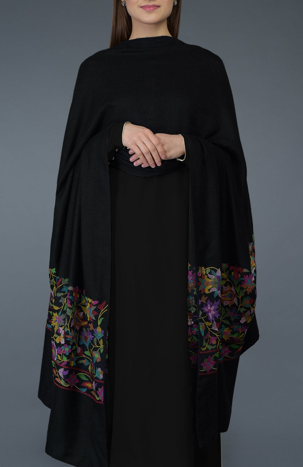 A woman models a black dupatta with colorful floral embroidery on the ends.