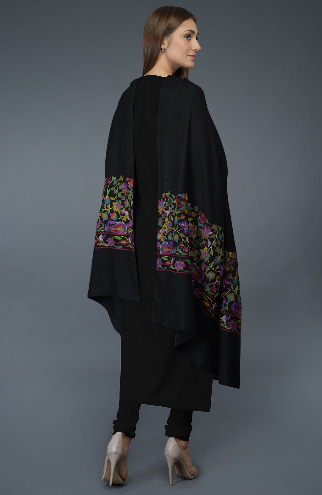 A woman models a black suit with a colorful embroidered dupatta.