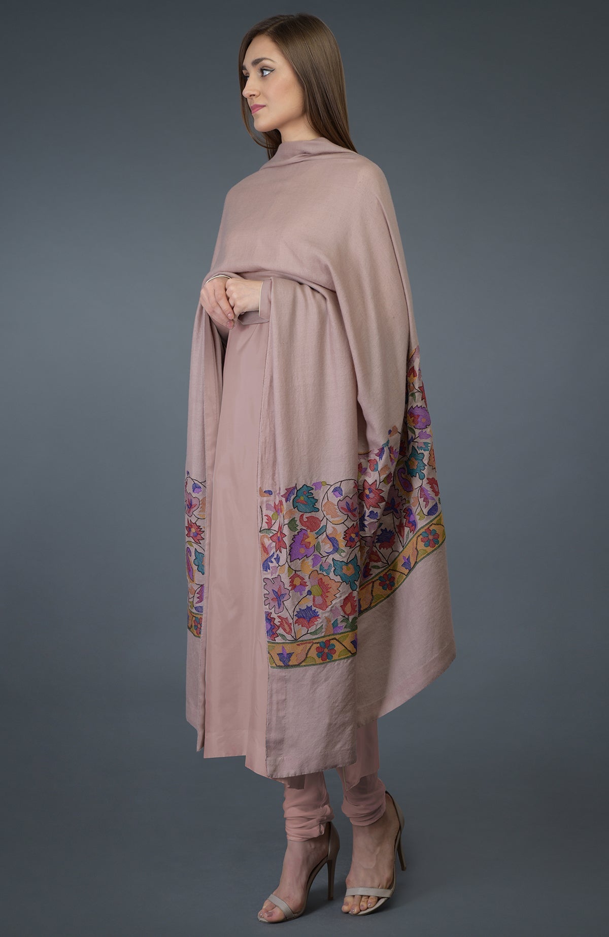 A woman models a dusty rose suit with a matching embroidered dupatta.