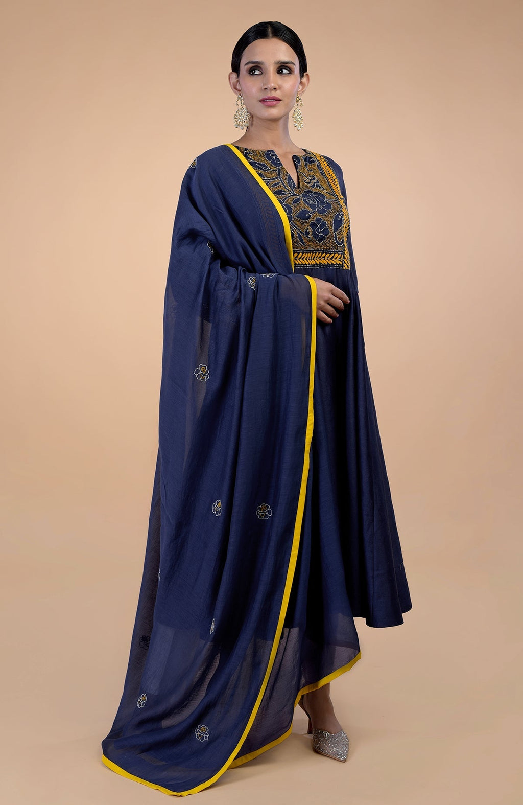 A woman models a navy blue Kantha hand-embroidered kalidaar kurta set.