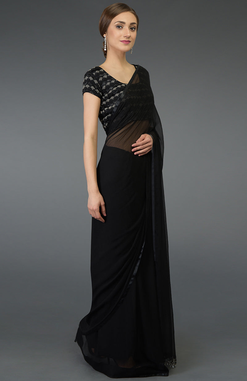 A woman models a black pure chiffon saree with a zardozi and beads work blouse.