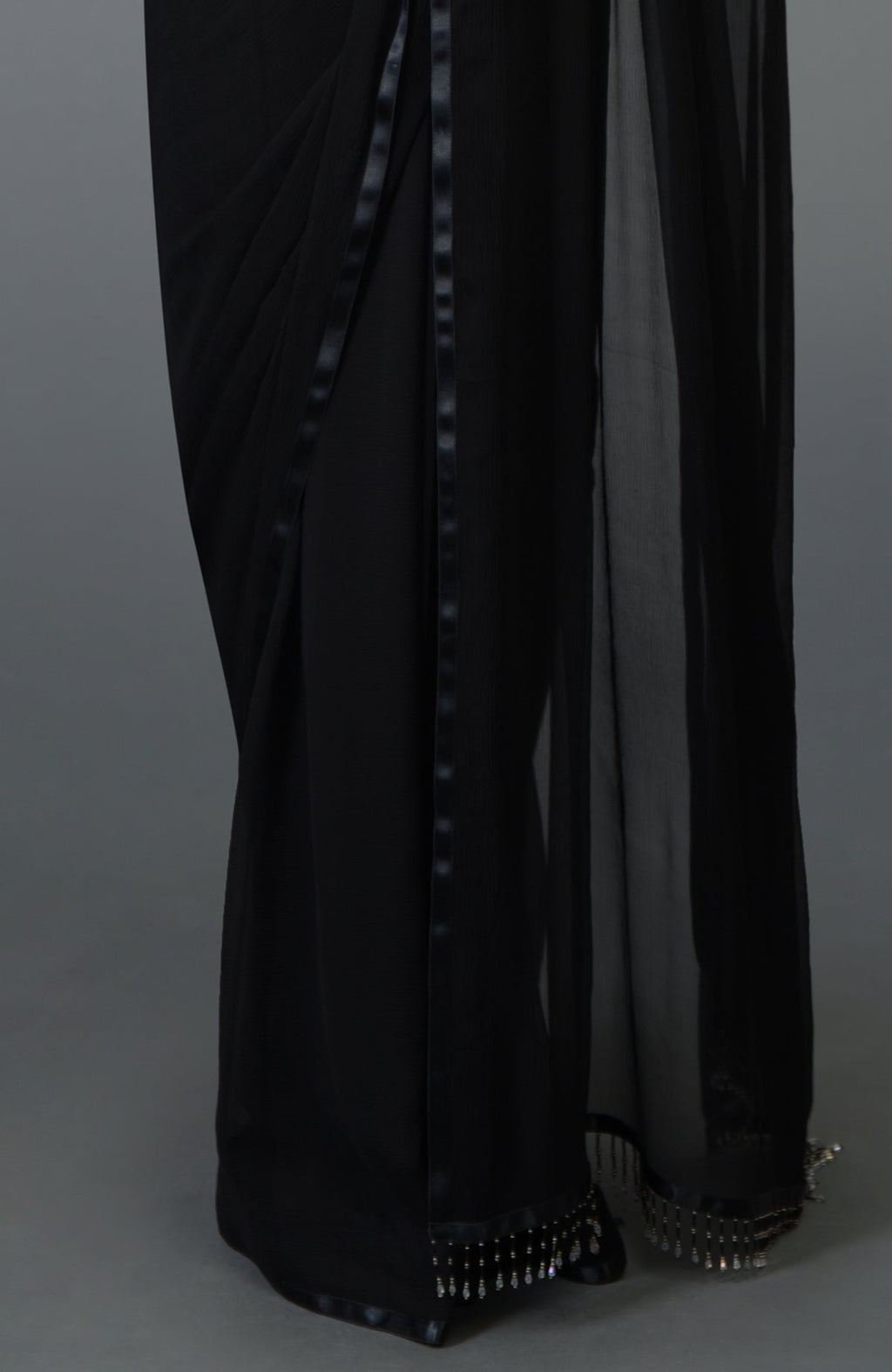 Black pure chiffon saree with satin border trims and beaded pallav fringe.
