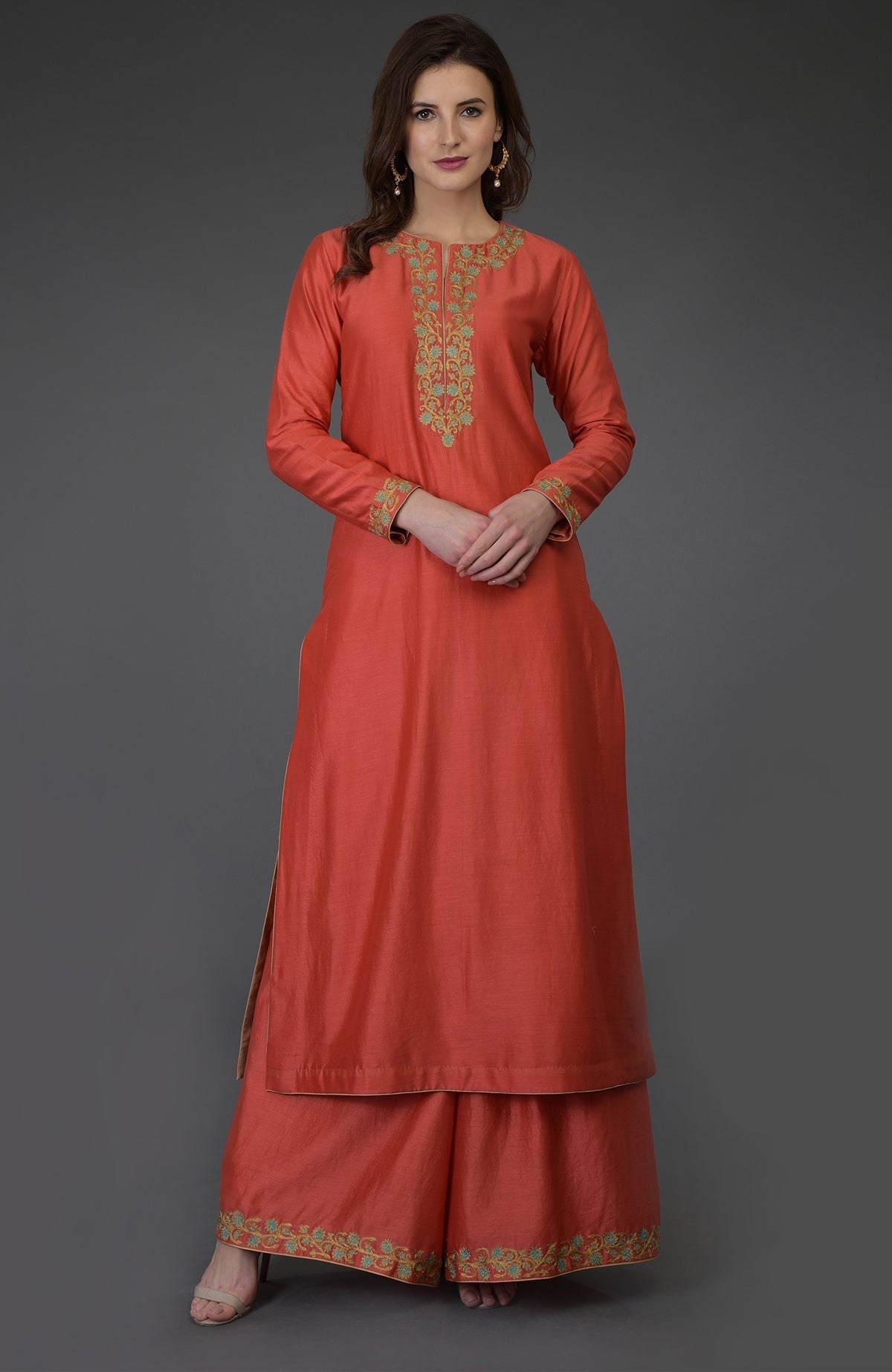 A woman models a living coral resham-tilla embroidered farshi palazzo suit.