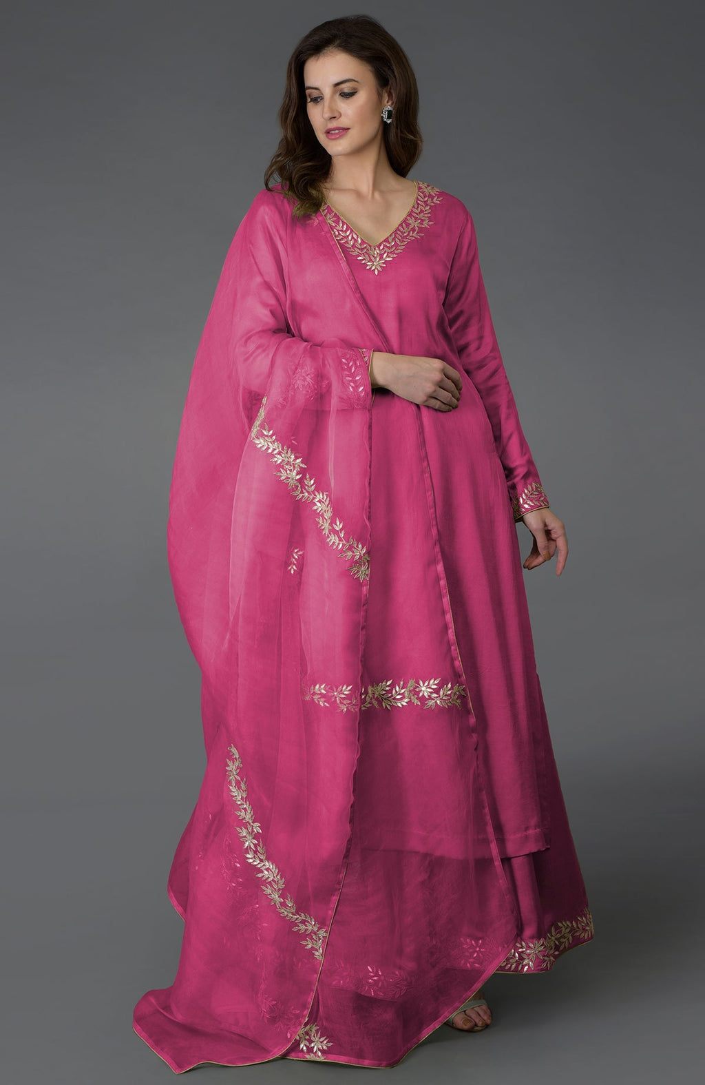 A woman models a chutney pink palazzo suit with gold gota patti embroidery.