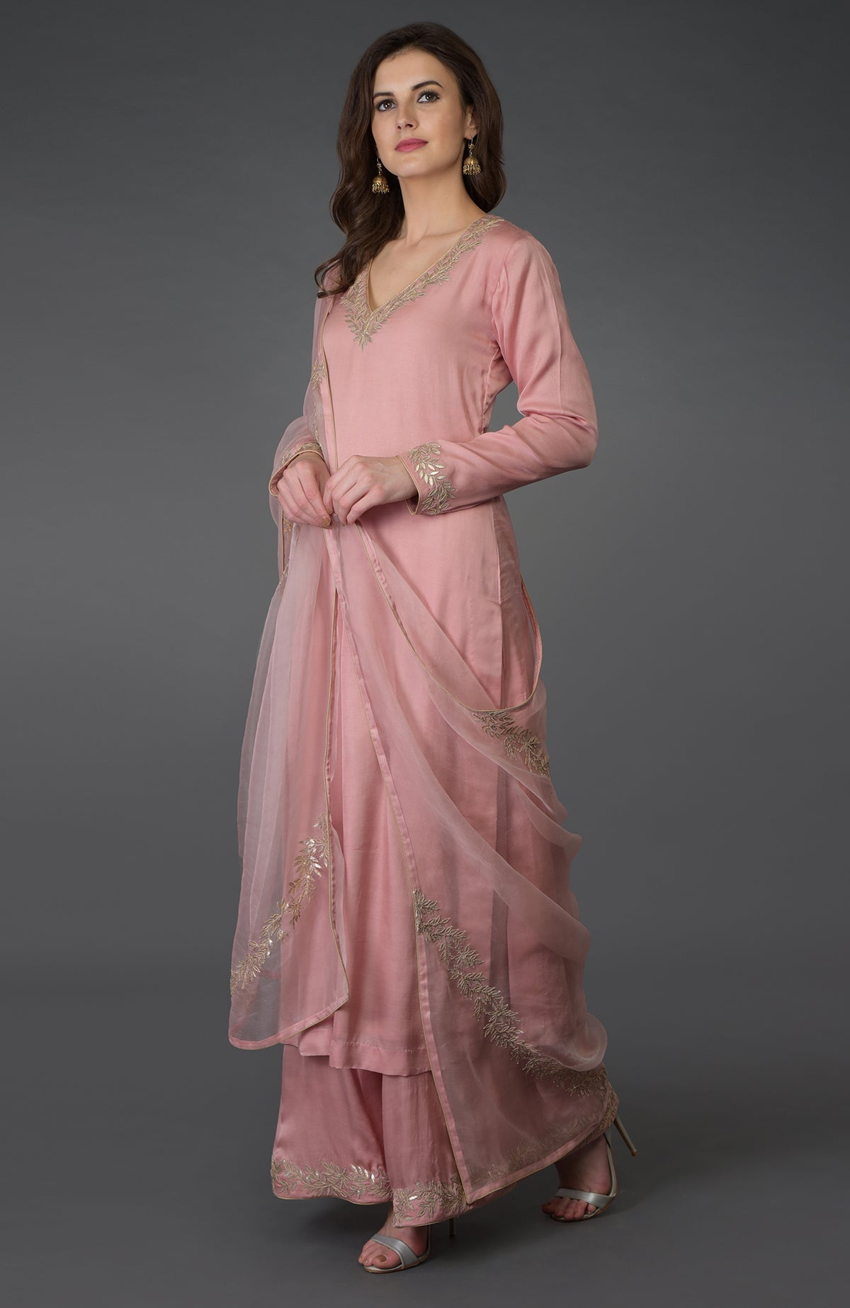 A woman models a pearl pink gota patti work farshi palazzo suit.