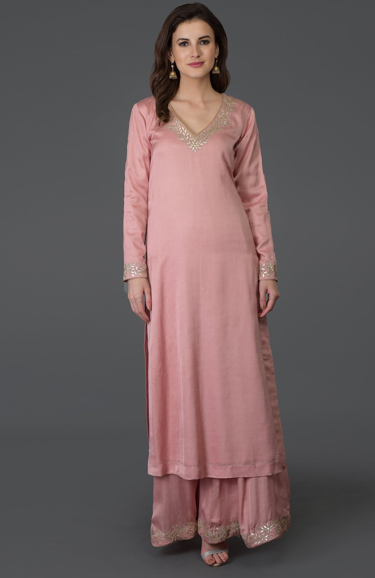 A woman models a pearl pink gota patti work farshi palazzo suit.