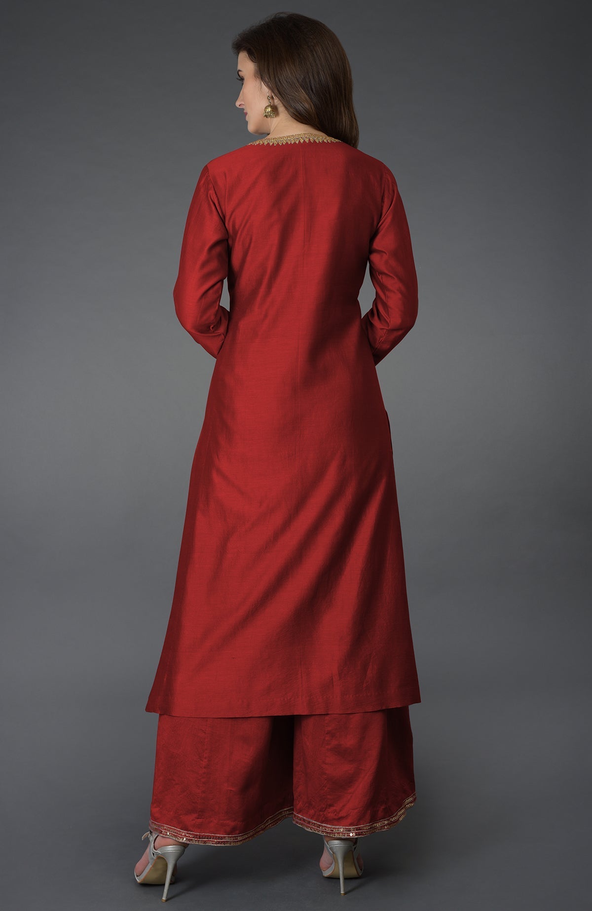 A woman models a red marori and sequin work farshi palazzo suit.