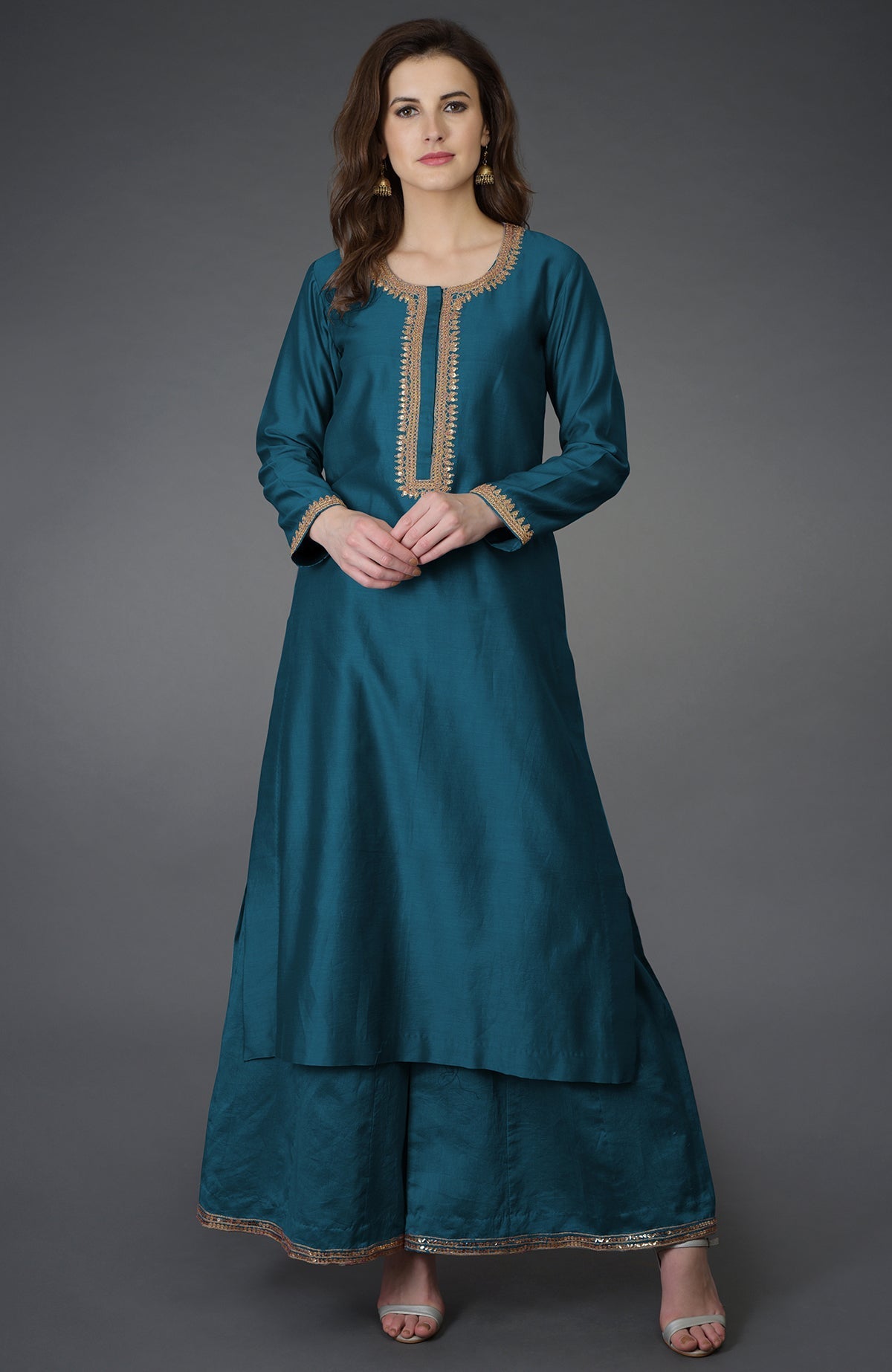 A woman models a peacock blue marori and sequin work farshi palazzo suit.