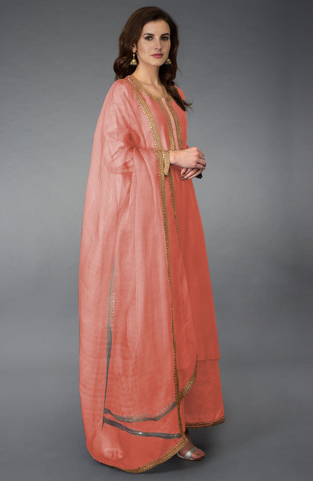 A woman models a terracotta marori and sequin work farshi palazzo suit.