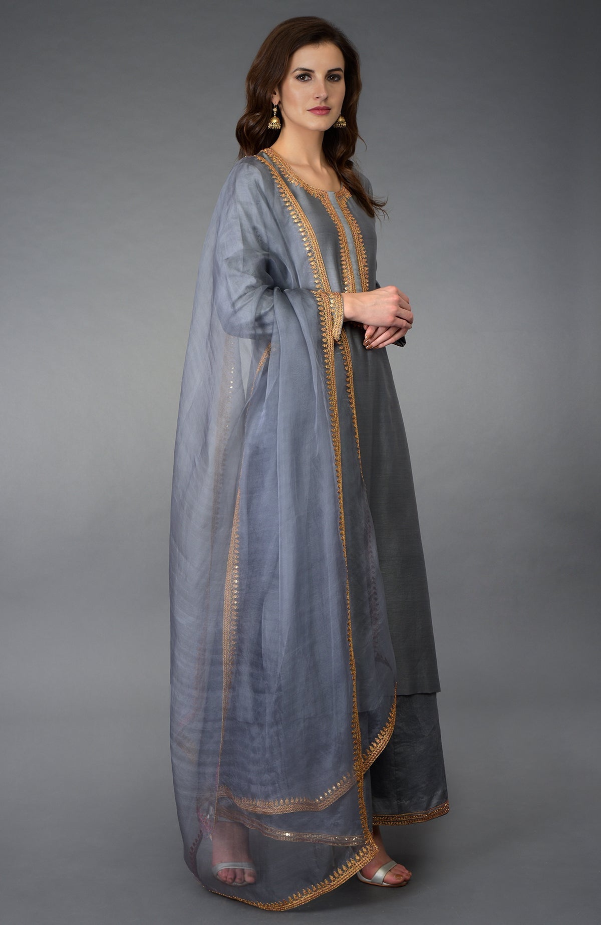 A woman models a grey marori and sequin work farshi palazzo suit.