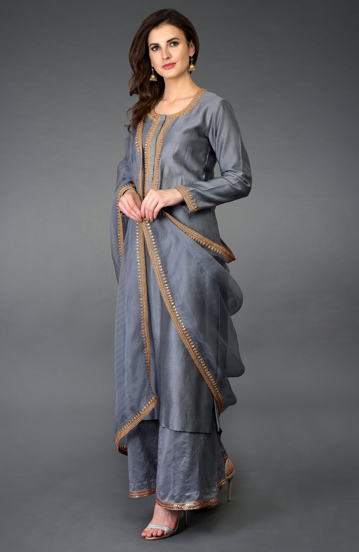A woman models a grey marori and sequin work farshi palazzo suit.