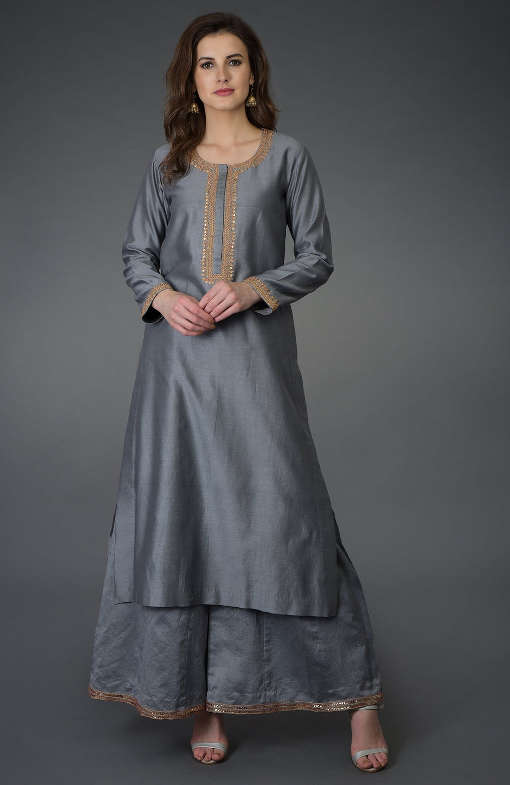A woman models a grey marori and sequin work farshi palazzo suit.