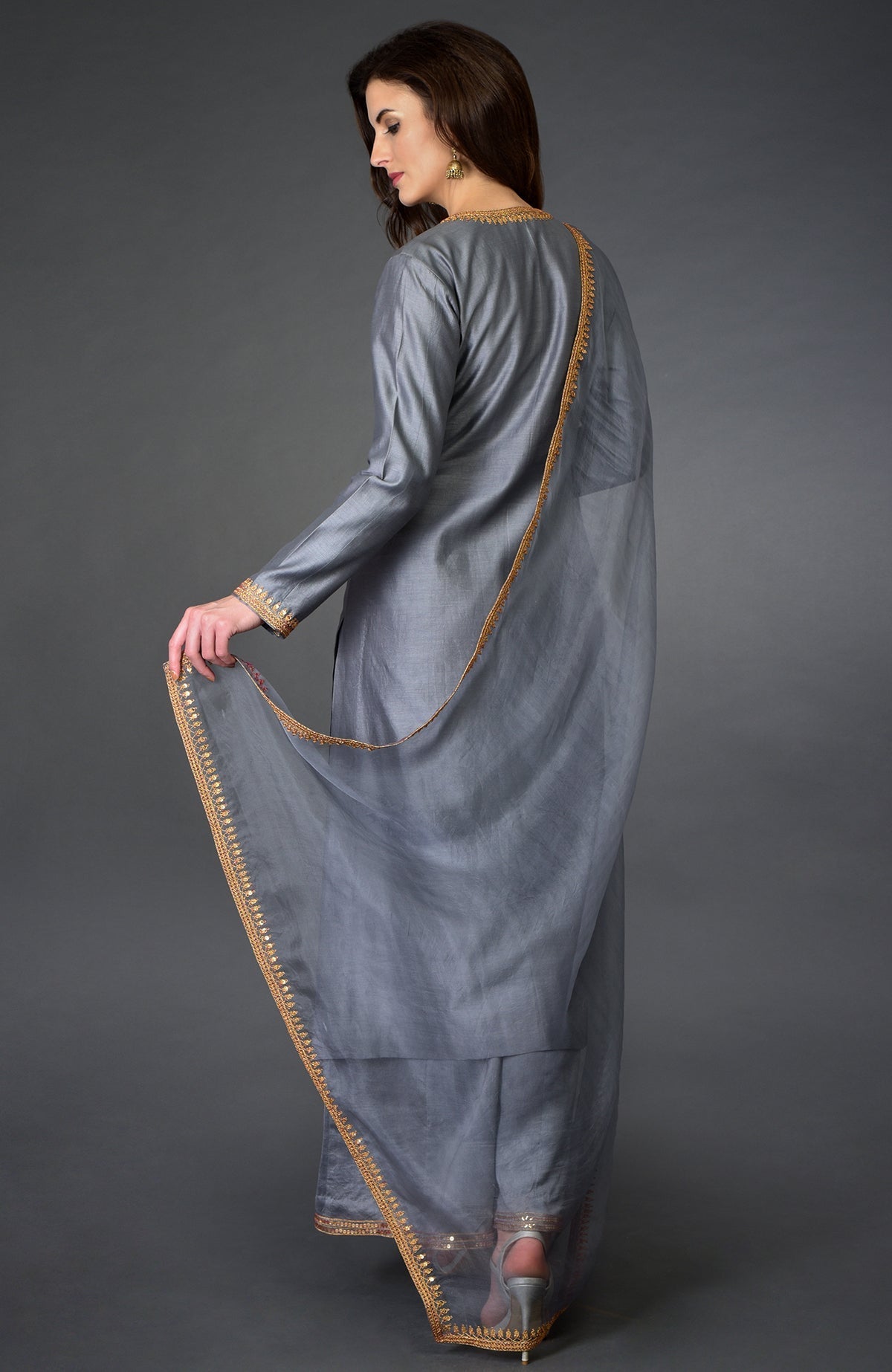 A woman models a grey marori and sequin work farshi palazzo suit.