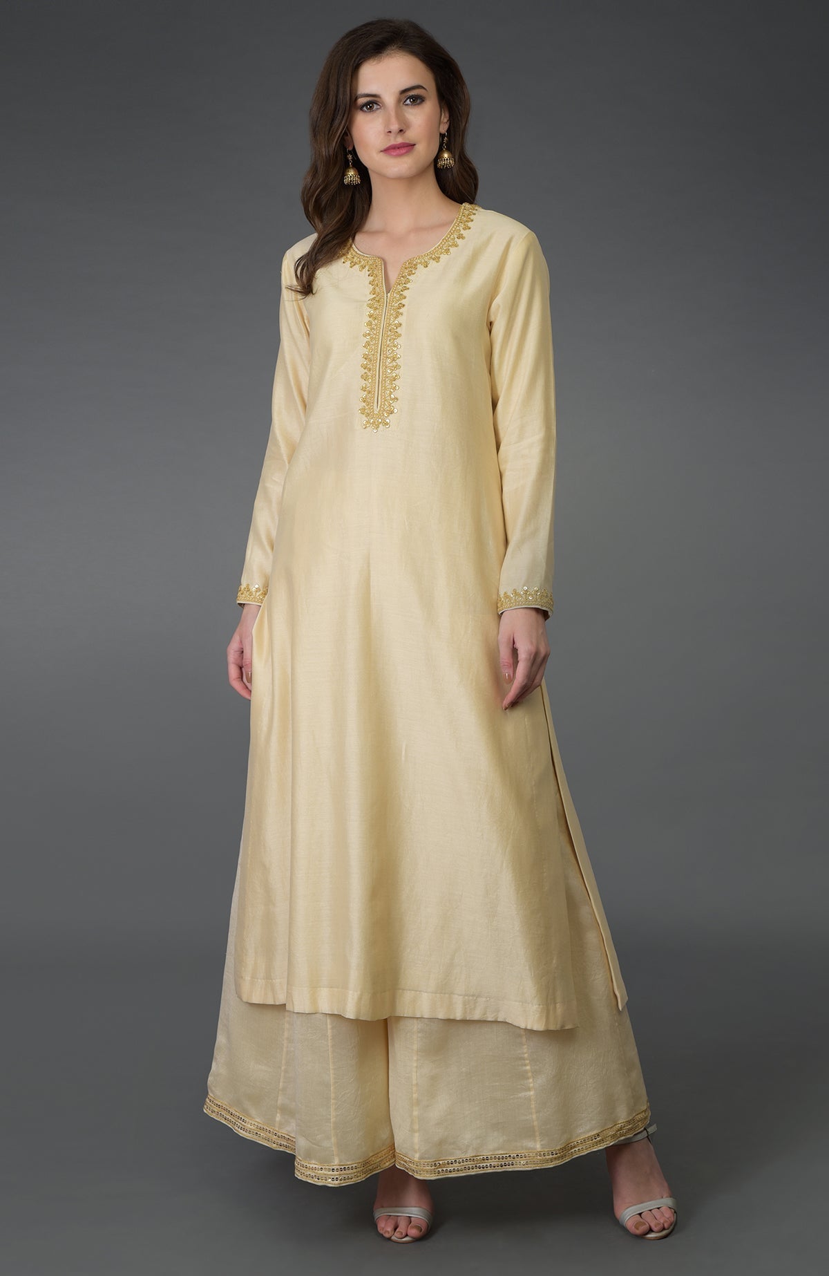 A woman models a cream marori and sequin work farshi palazzo suit.