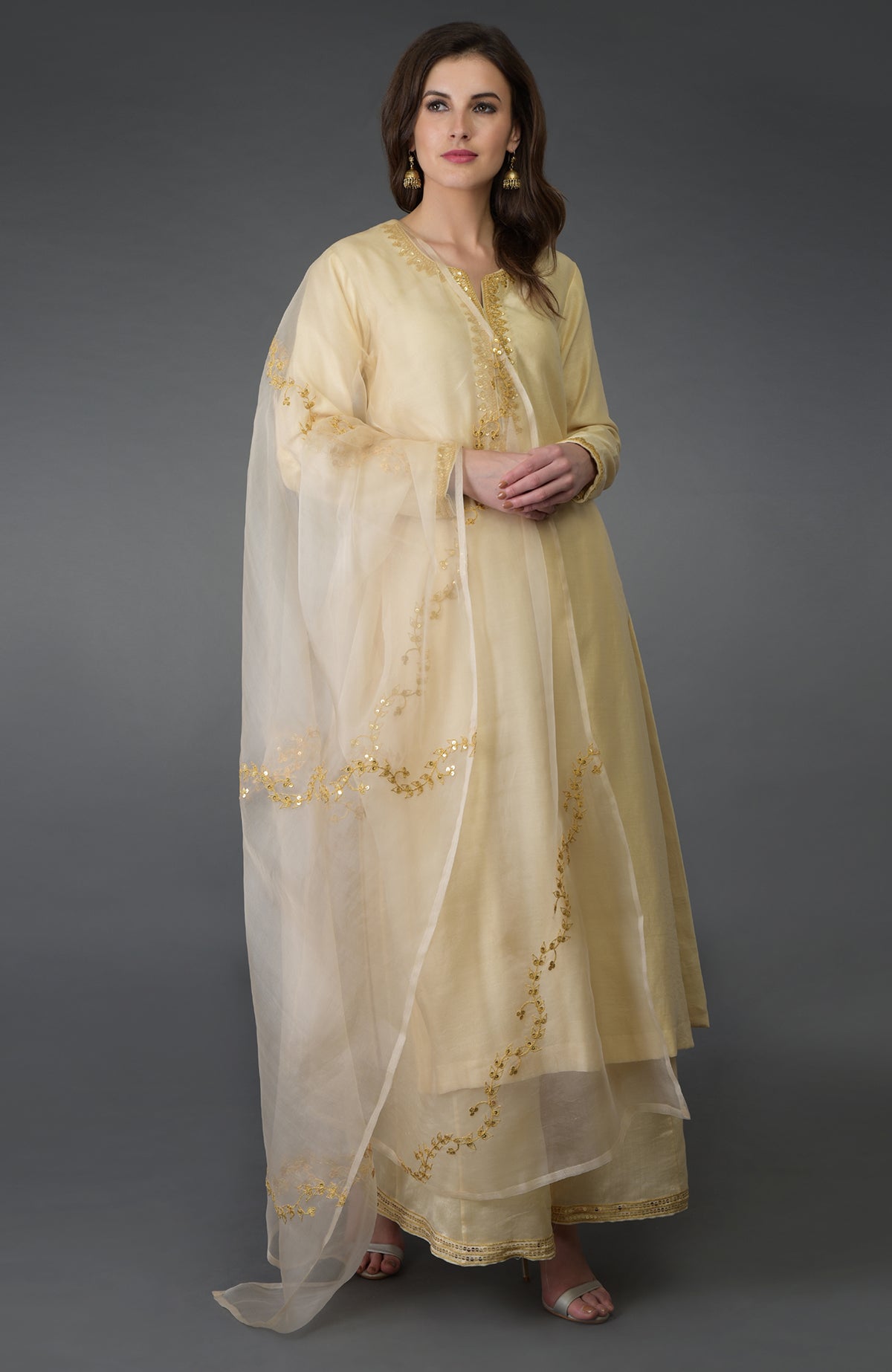 A woman models a cream marori and sequin work farshi palazzo suit.