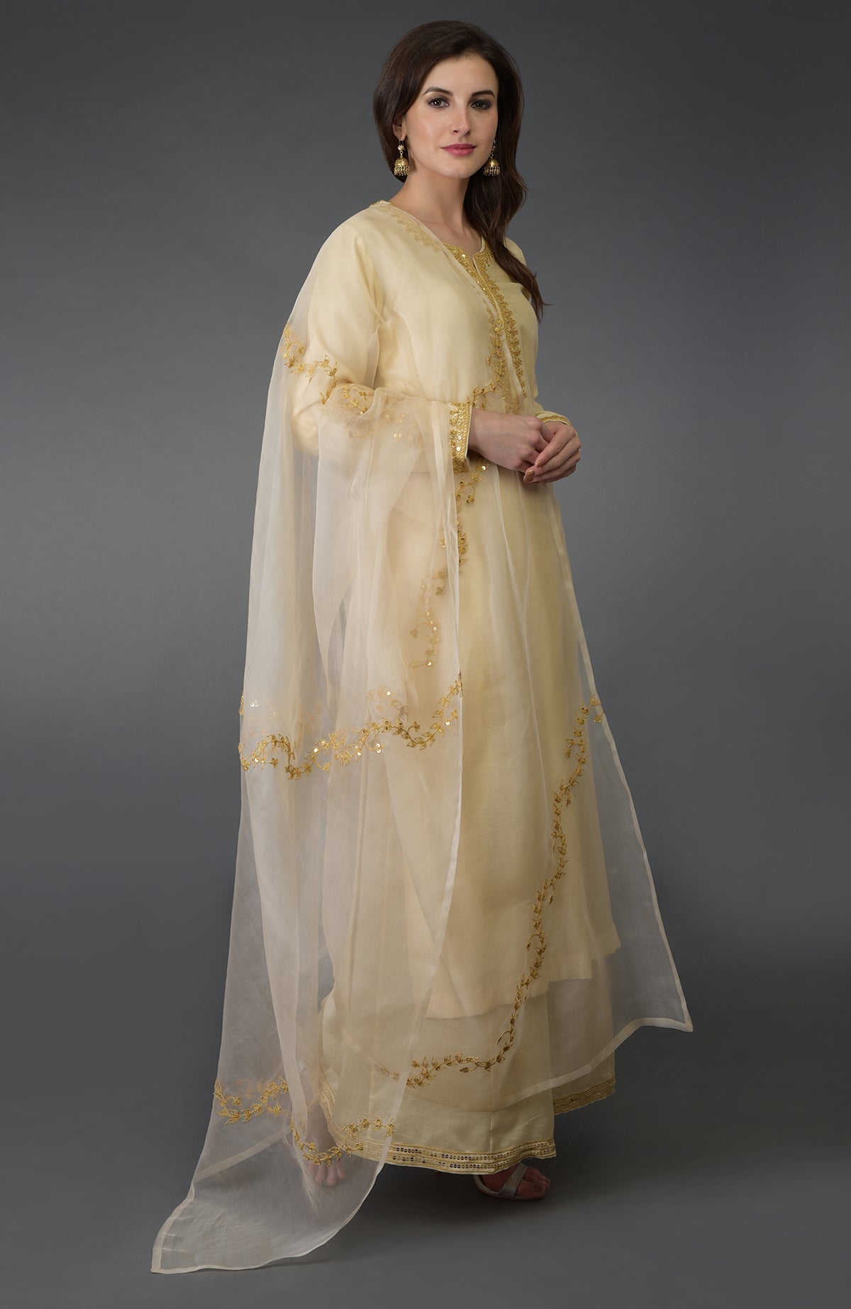 A woman models a cream Marori and Sequin Work Farshi Palazzo Suit.