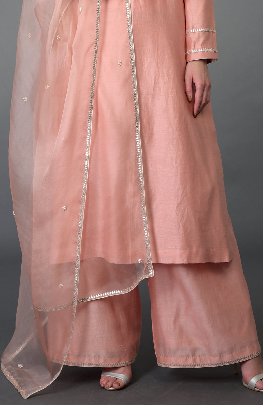 A model wears a pressed rose farshi suit with a sheer dupatta.