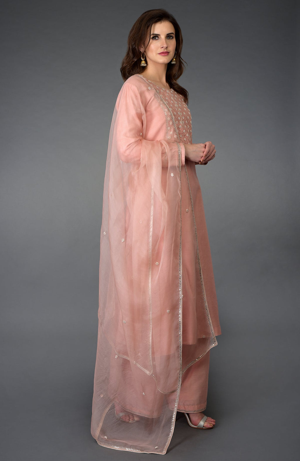 A woman models a pressed rose zardozi gota patti and pearl beads farshi suit.