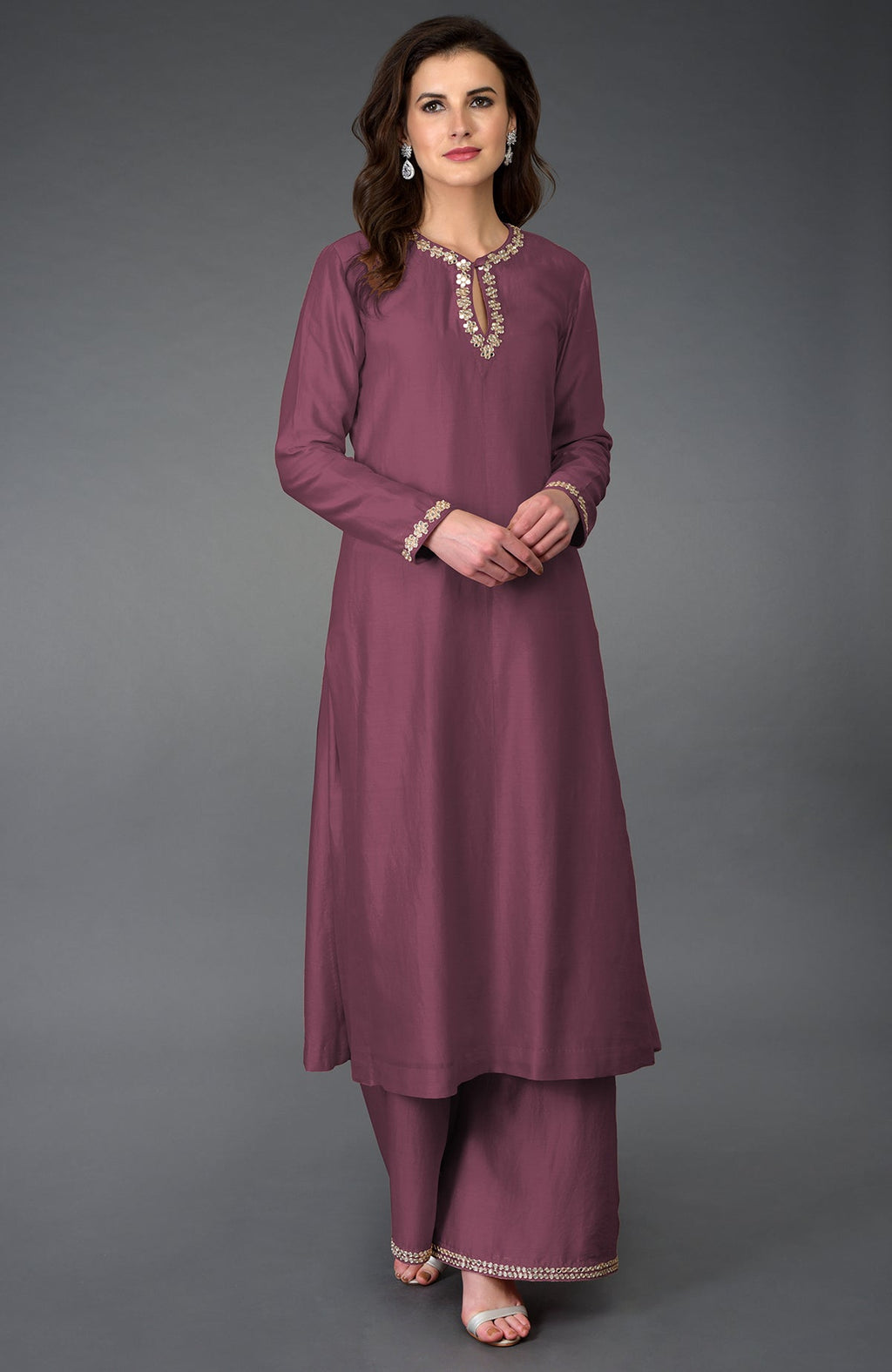 A woman models a burgundy purple gota patti and mirror work farshi palazzo suit.