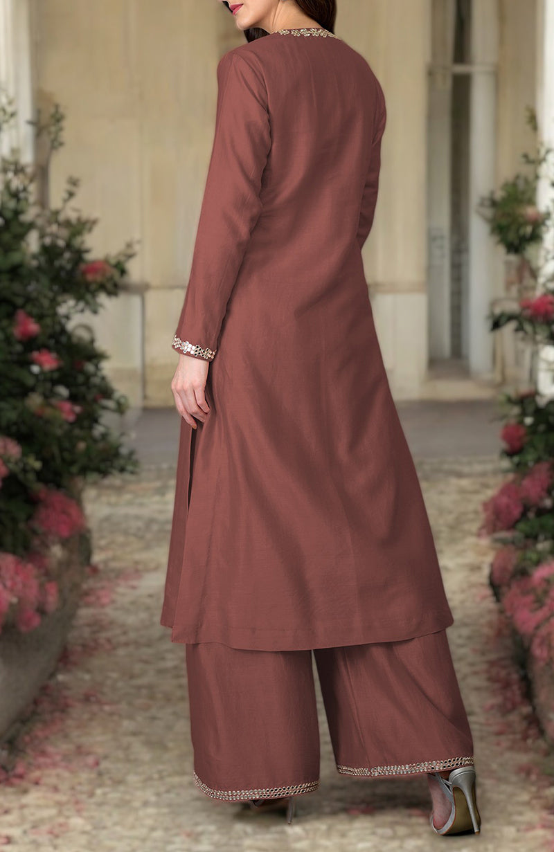 A woman models a chutney-colored palazzo suit with intricate embroidery.
