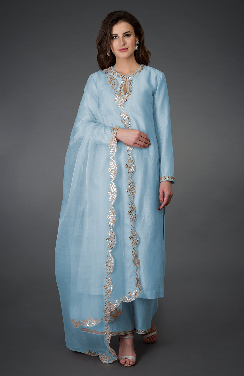 A woman models a light blue palazzo suit with mirror and gota patti embroidery.