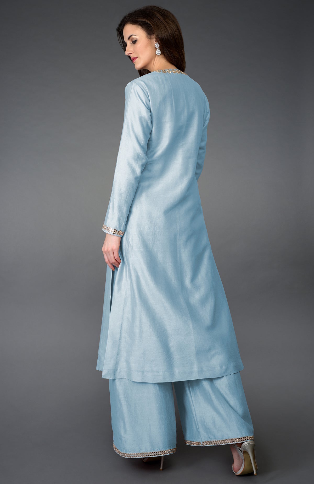A woman models a light blue palazzo suit with mirror and gota patti embroidery.