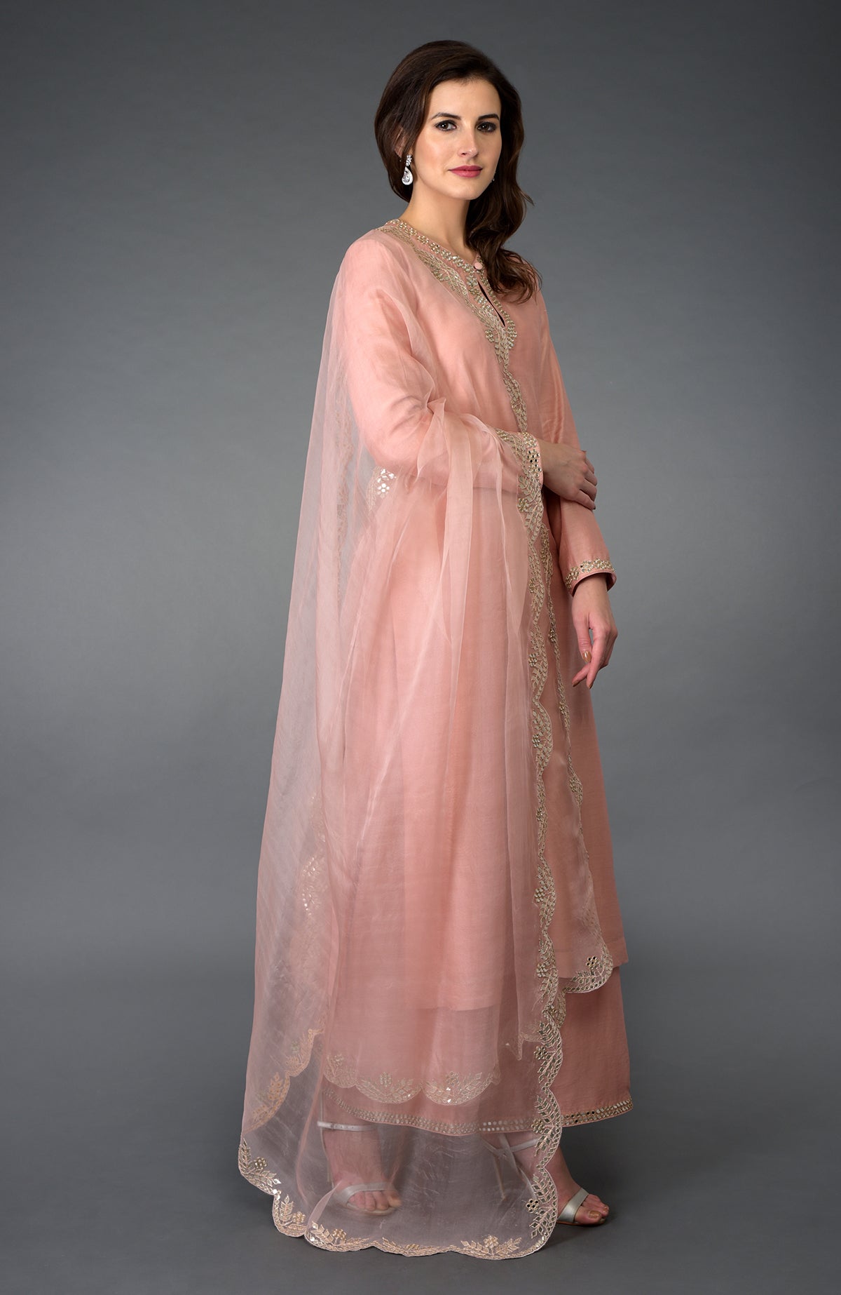 A woman models a pressed rose gota patti and mirror work farshi palazzo suit.