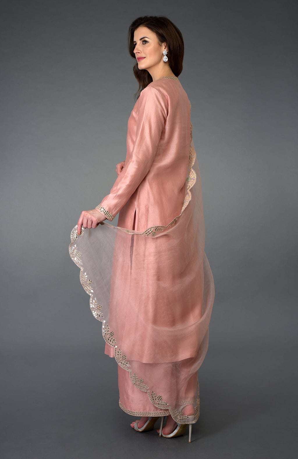 A woman models a pressed rose gota patti and mirror work farshi palazzo suit.