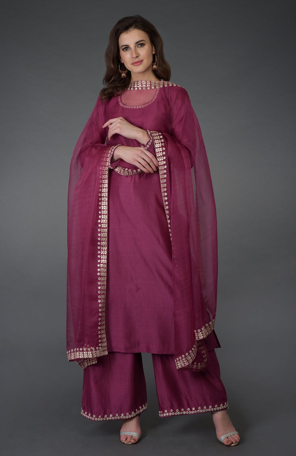 A woman models a burgundy Zardozi Gota Patti and crystal work Farshi suit.