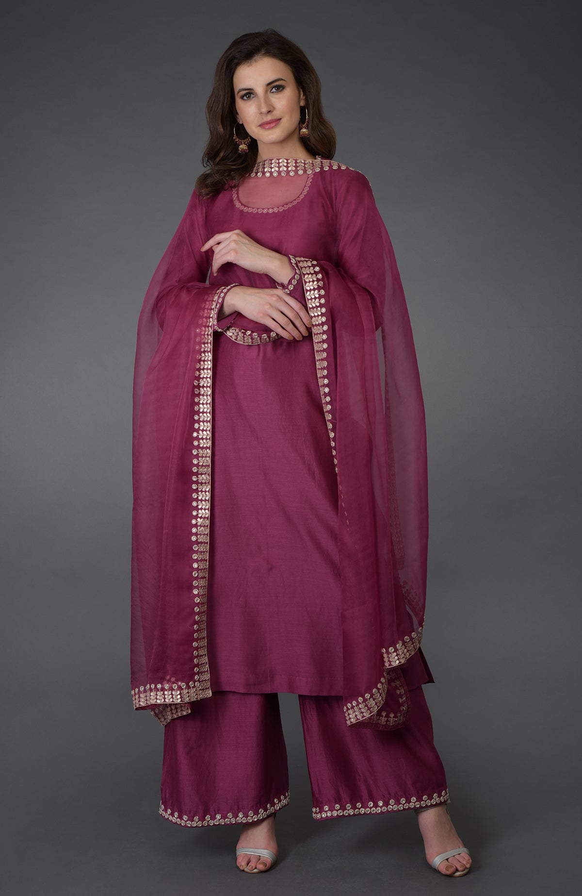 A woman models a burgundy Zardozi Gota Patti and crystal work Farshi suit.