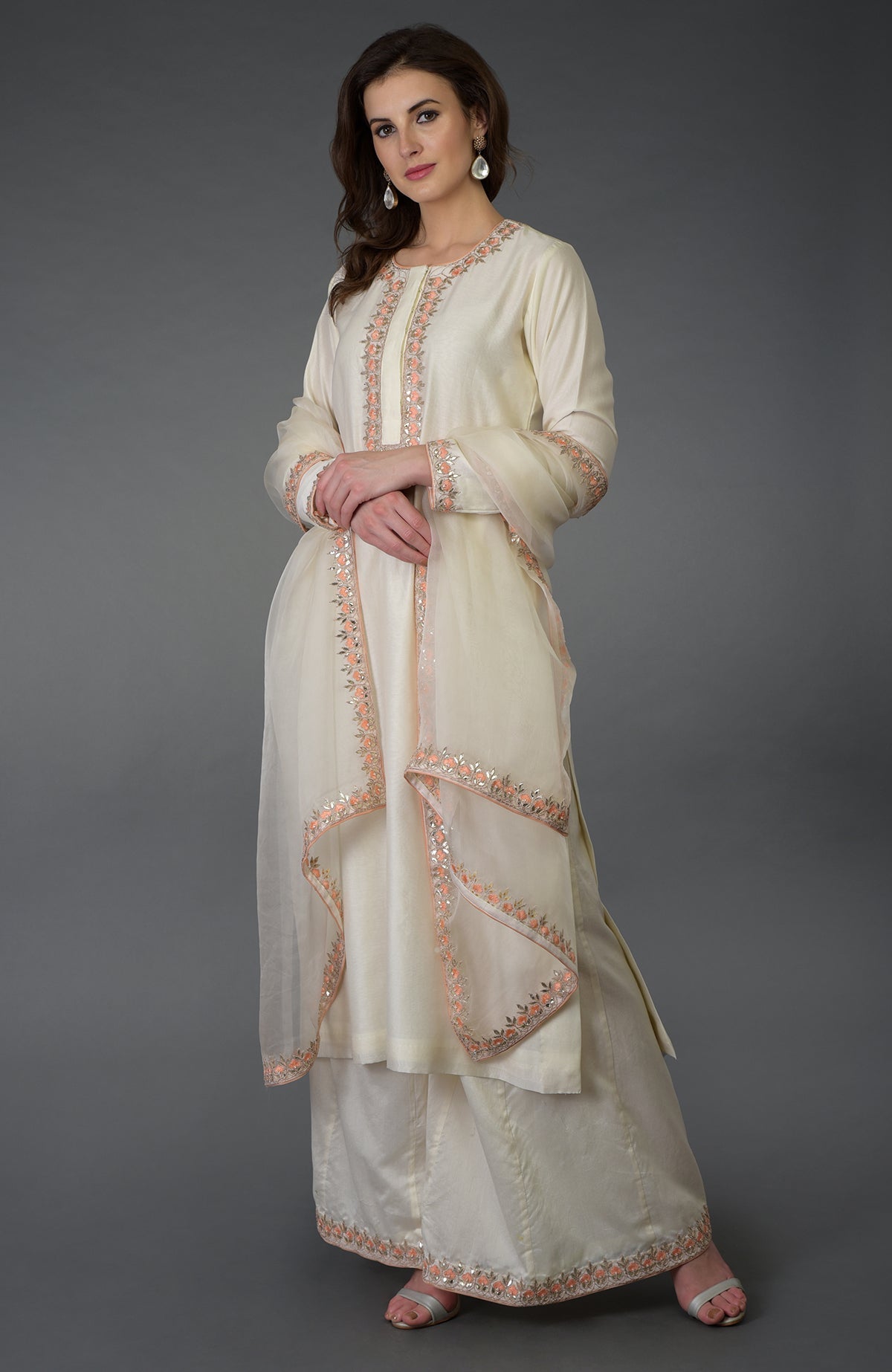 A woman models a cream Chutney Resham Gota Patti and Pearl Beads Farshi Palazzo Suit.