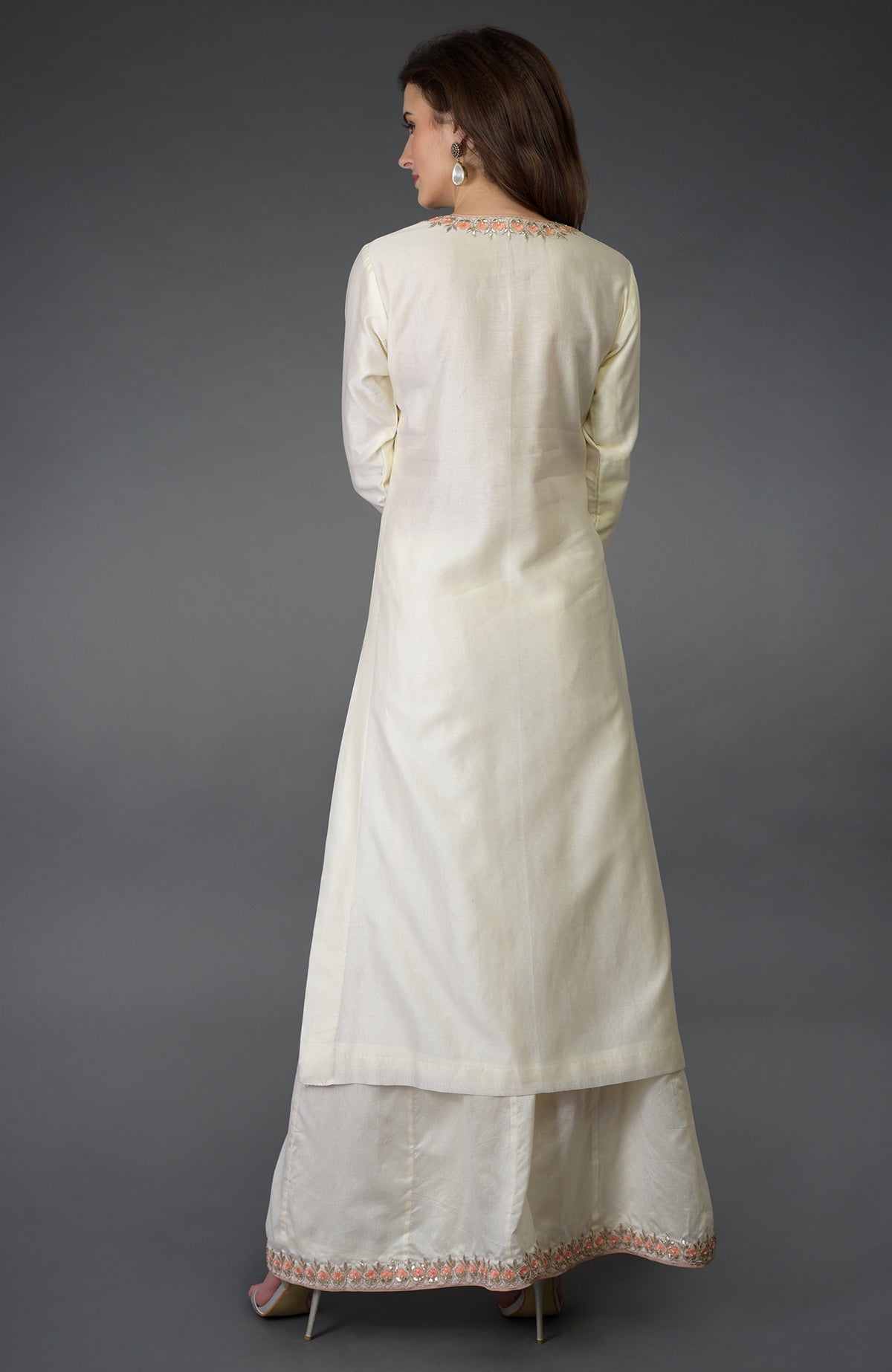 A woman models an ivory Resham Gota Patti and Pearl Beads Farshi Palazzo Suit.