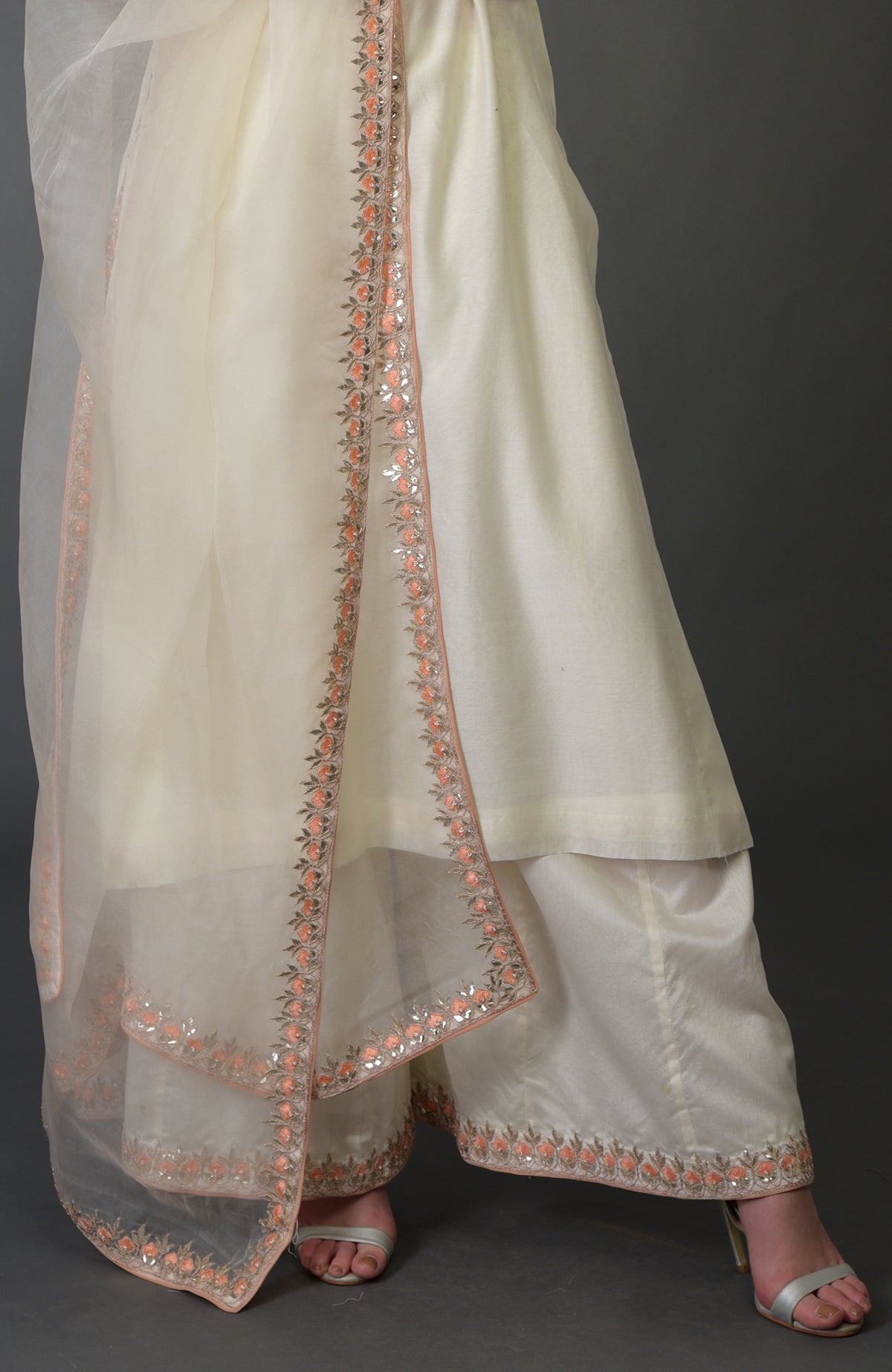 An ivory palazzo suit with resham, gota patti, and pearl bead embroidery.