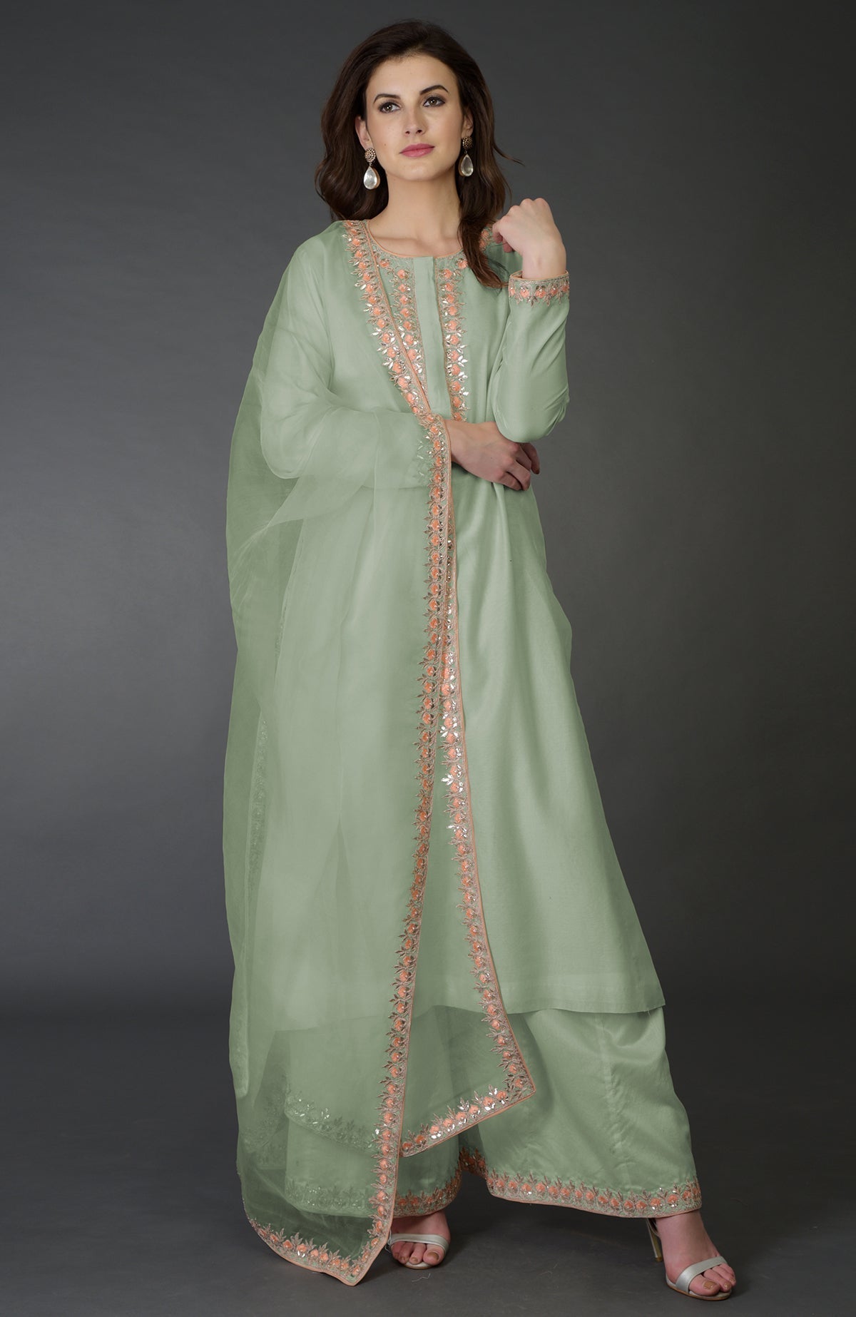 A woman models an Ivory Resham Gota Patti and Pearl Beads Farshi Palazzo Suit.