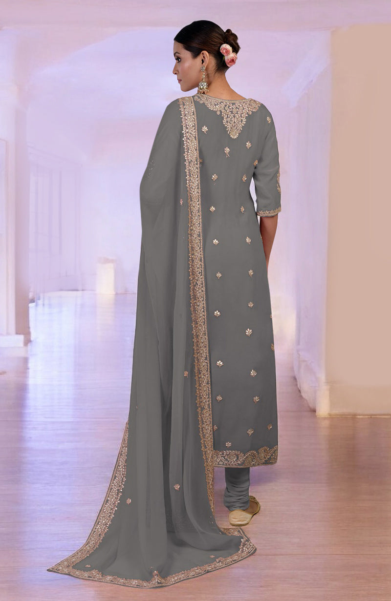 A woman models a grey kurta set with gold embroidery and a matching dupatta.